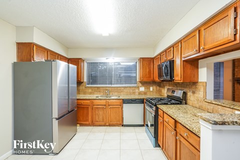 A kitchen with wooden cabinets and a granite countertop.