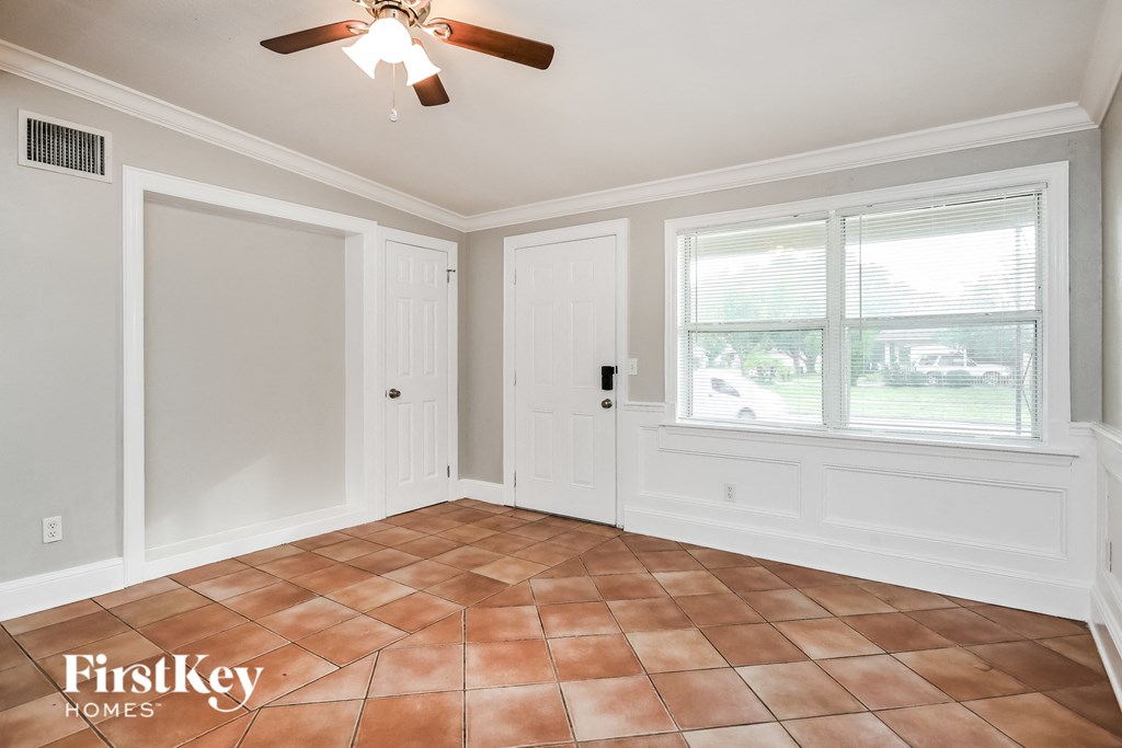 a dining room with a large window and a ceiling fan