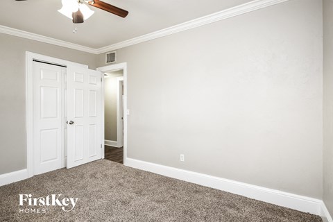 a bedroom with a ceiling fan and a white door