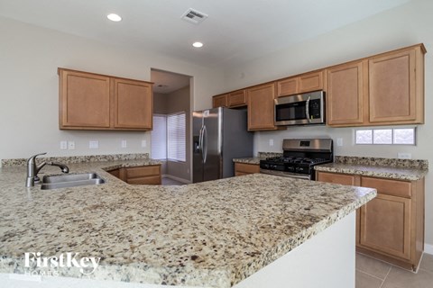 A kitchen with granite countertops and wooden cabinets.
