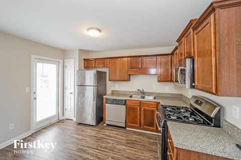 A kitchen with wooden cabinets and a stainless steel refrigerator.