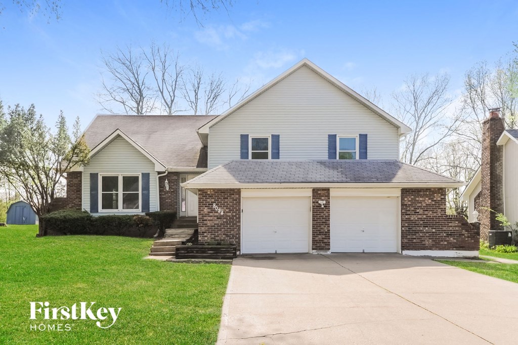 a white house with a white garage door and a green lawn