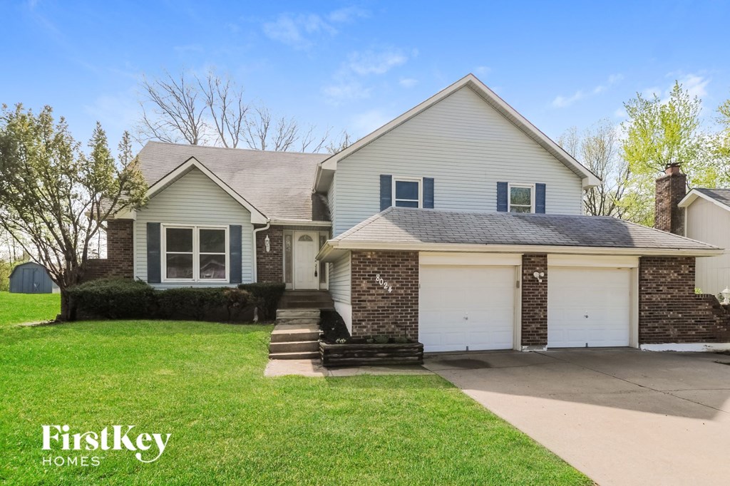 a white house with a white garage door and a green lawn