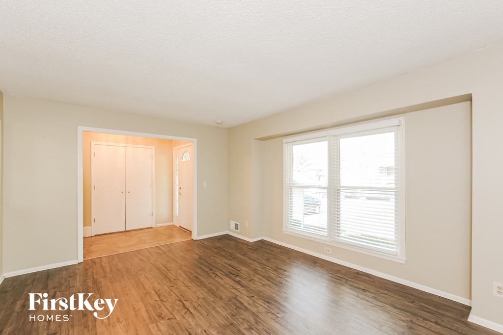 a living room with wood flooring and a large window