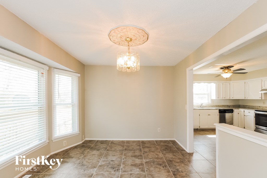 a dining room and kitchen with a ceiling fan and a chandelier