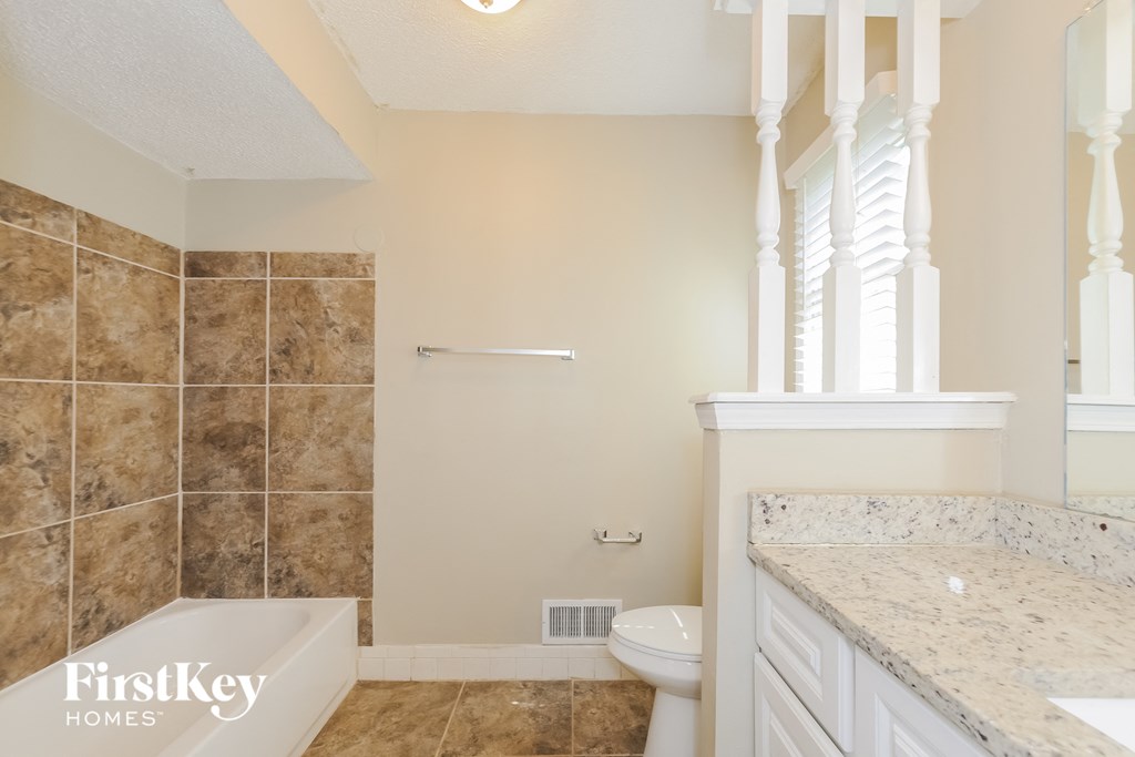 a bathroom with a tub and a toilet and a sink