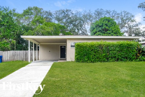 a small white house with a lawn and a sidewalk