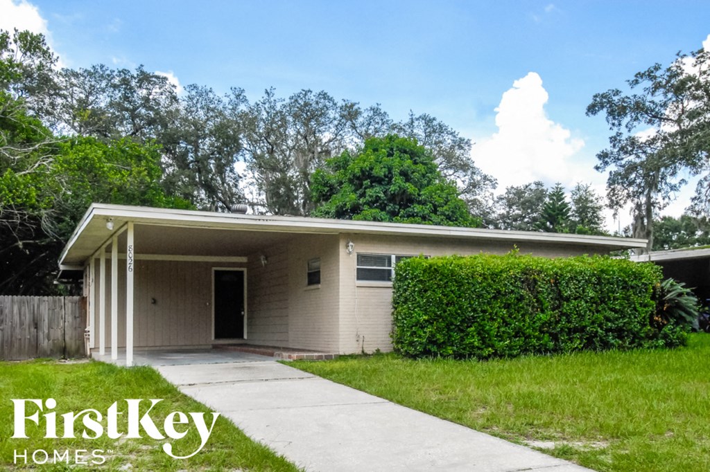a small white house with a yard and a sidewalk
