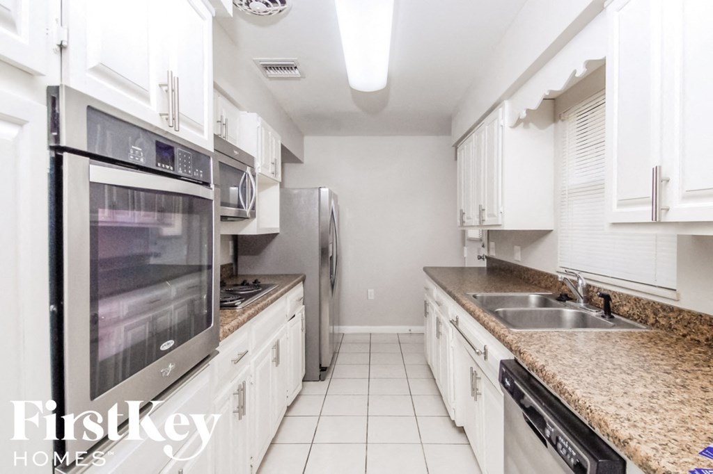 a kitchen with white cabinets and granite counter tops