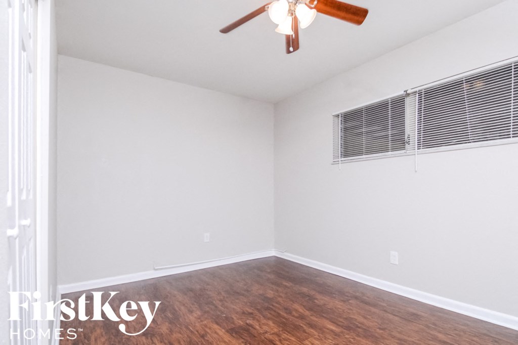 a bedroom with a ceiling fan and a window