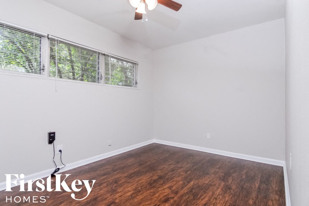 an empty room with wood flooring and a window