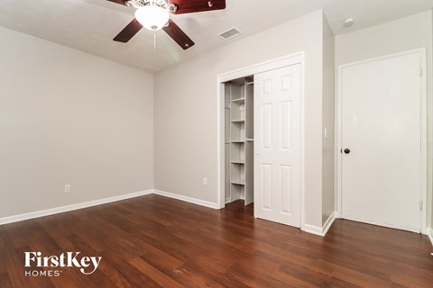 the living room with a closet and a ceiling fan