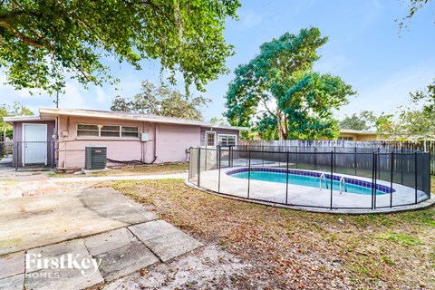 a backyard with a pool and a house with a fence