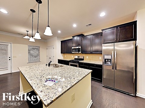 A kitchen with granite countertops and stainless steel appliances.