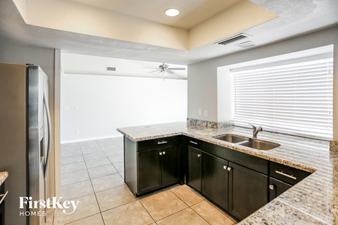 a kitchen with black cabinets and a stainless steel refrigerator