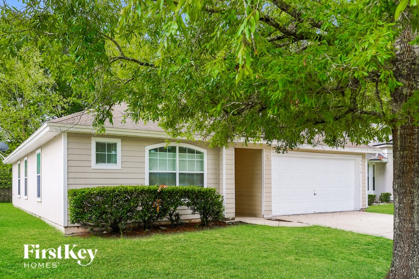 a white house with a tree in front of it