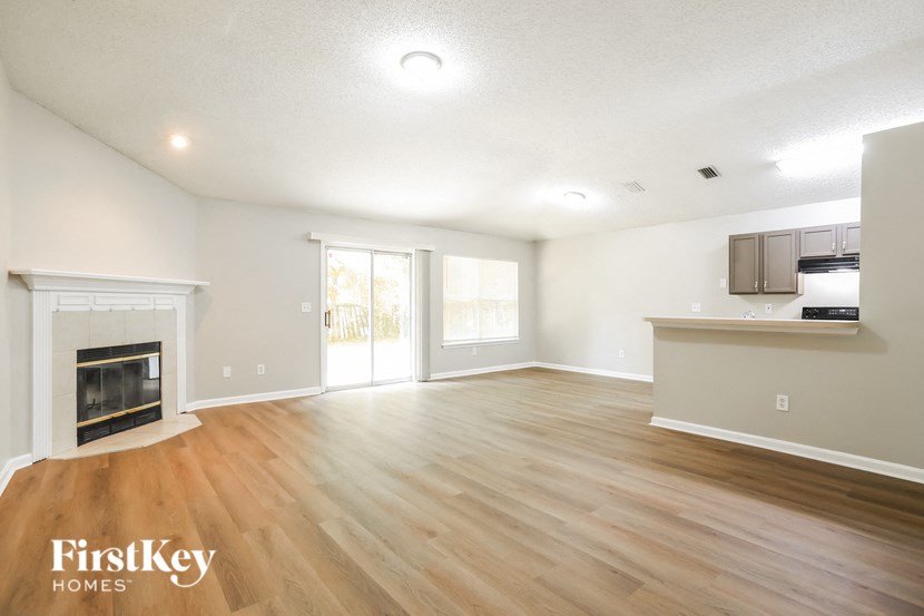 a living room with a fireplace and wooden floors