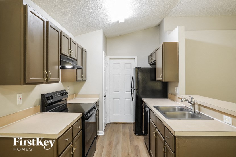 a kitchen with wood flooring and stainless steel appliances and