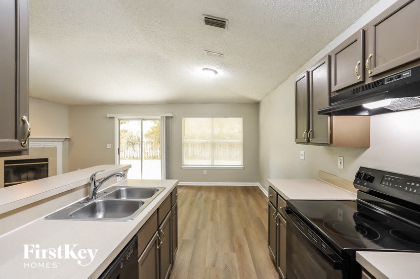 a kitchen with a sink and a stove and a window