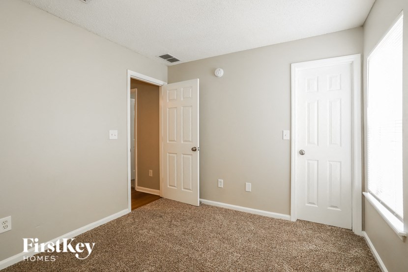 a bedroom with two doors and a carpeted floor