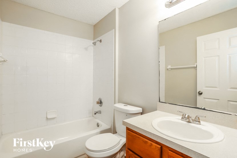a bathroom with a sink toilet and tub and a mirror