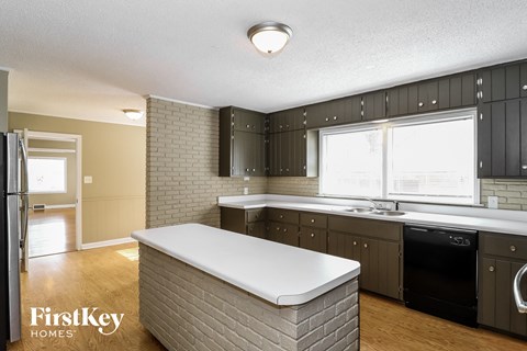 a kitchen with black cabinets and a white counter top