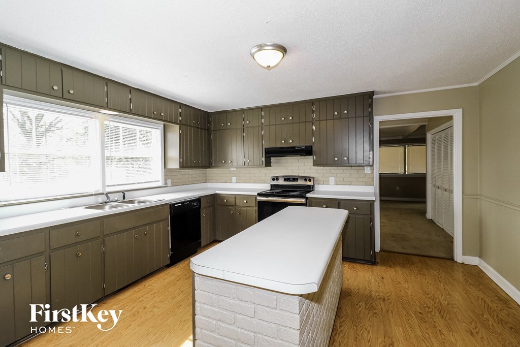 a kitchen with a white counter top and dark cabinets