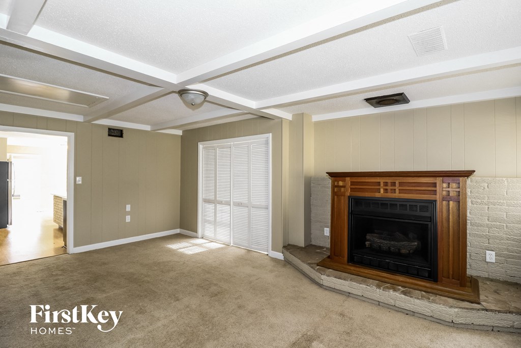 a living room with a fireplace and a carpeted floor