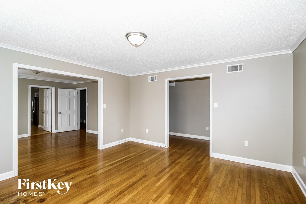 the living room and dining room of an empty house with wood floors