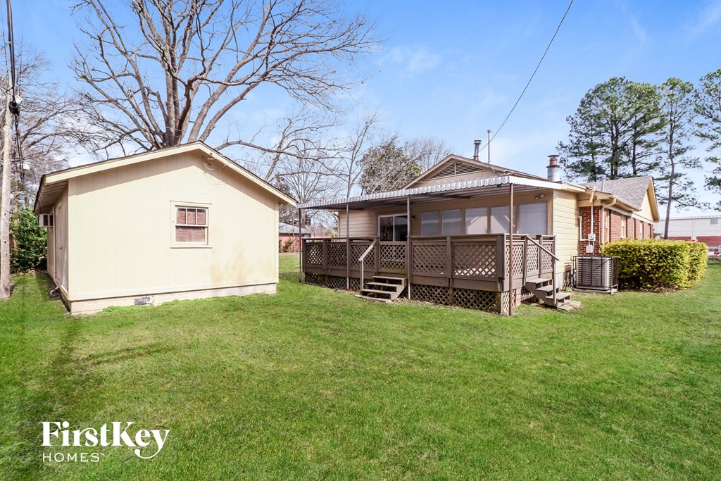 a small house with a yard and a deck
