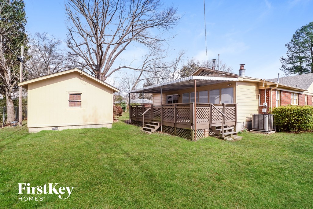 a backyard with a house and a yard with a deck