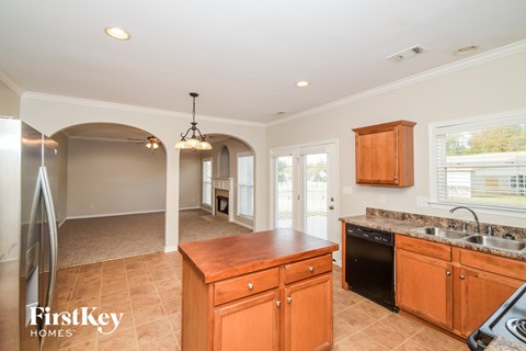 A kitchen with wooden cabinets and a black dishwasher.