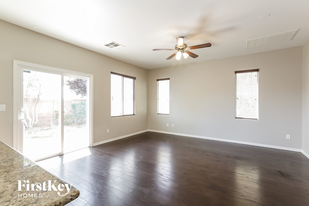 A spacious room with a ceiling fan and sliding glass doors.