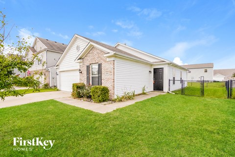 A house with a white garage door and a brick wall.