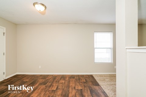 A room with wooden flooring and a window letting in natural light.