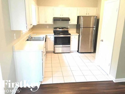 A kitchen with white cabinets and appliances.