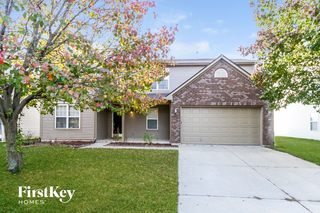 front view of a house with a driveway and a garage door