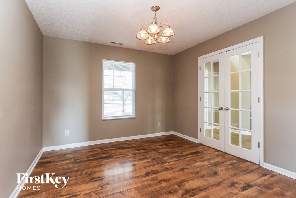 the living room of a house with a hardwood floor and a white door
