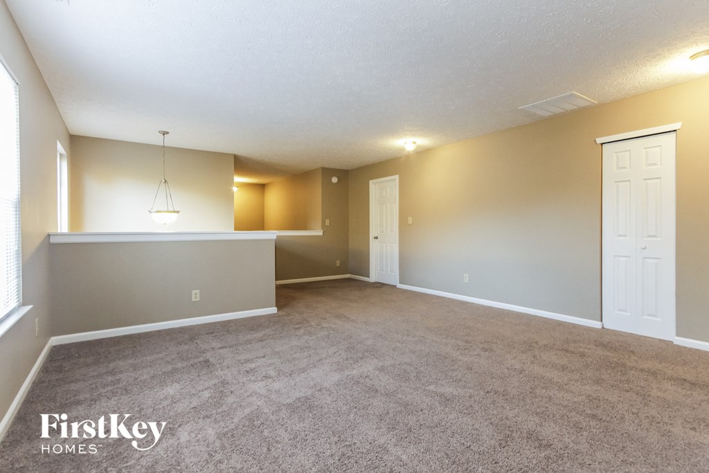 the living room and dining room of an empty house
