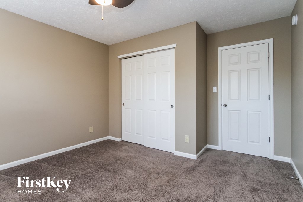 a bedroom with two doors and a carpeted floor