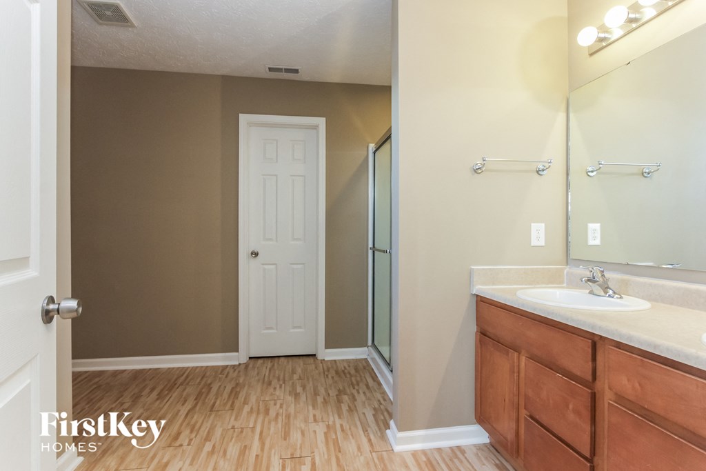 a bathroom with a sink and a shower and a mirror