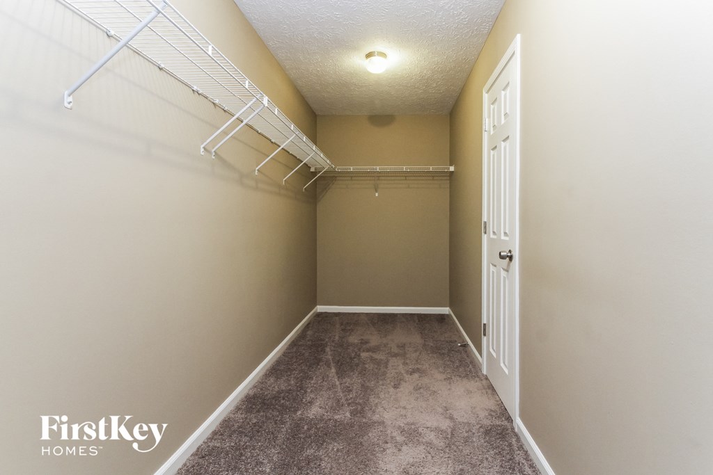 an empty bedroom with a closet and a door to the bathroom