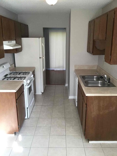 an empty kitchen with a sink and a refrigerator