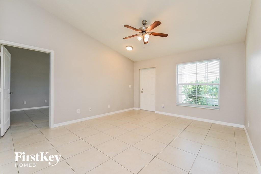 a clean and empty living room with a ceiling fan