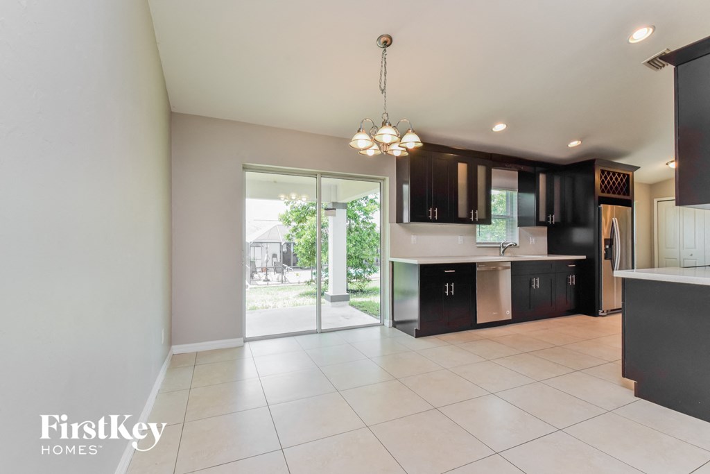 an open kitchen and living room with a sliding glass door to the backyard
