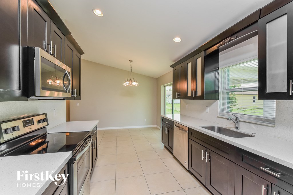 a kitchen with black cabinets and white counter tops and a sink