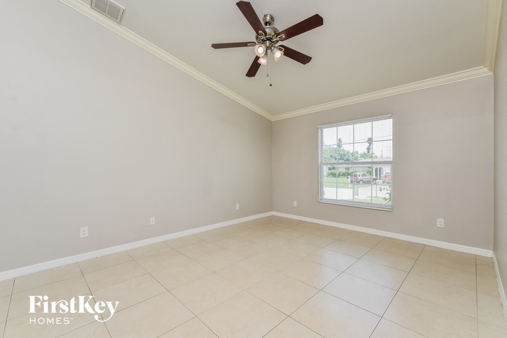an empty living room with a ceiling fan