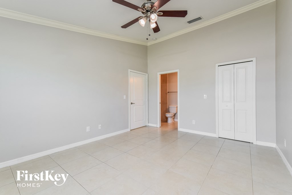 a clean and empty living room with a ceiling fan