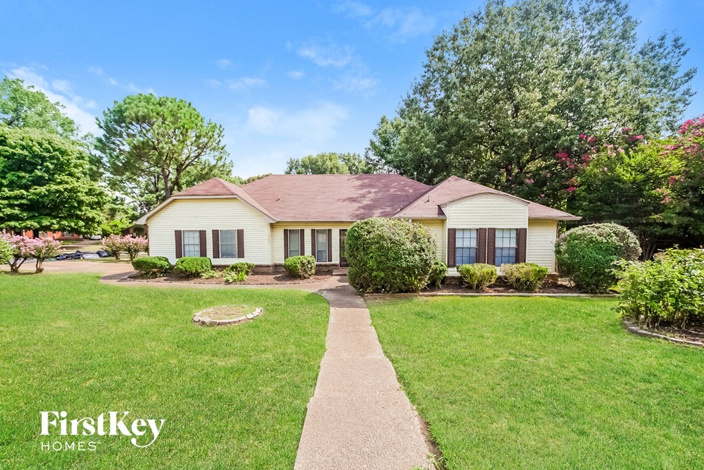 a home with a lawn and a sidewalk in front of it