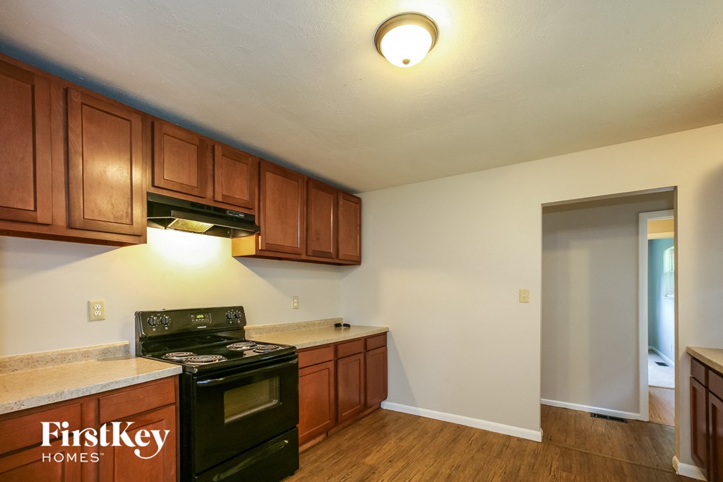 a kitchen with wooden cabinets and a black stove and an oven